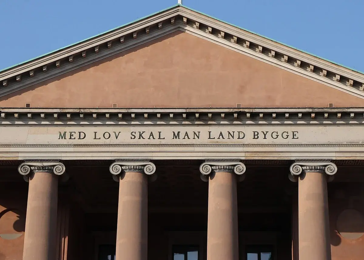 Classical courthouse facade in Copenhagen with columns and Danish inscription.