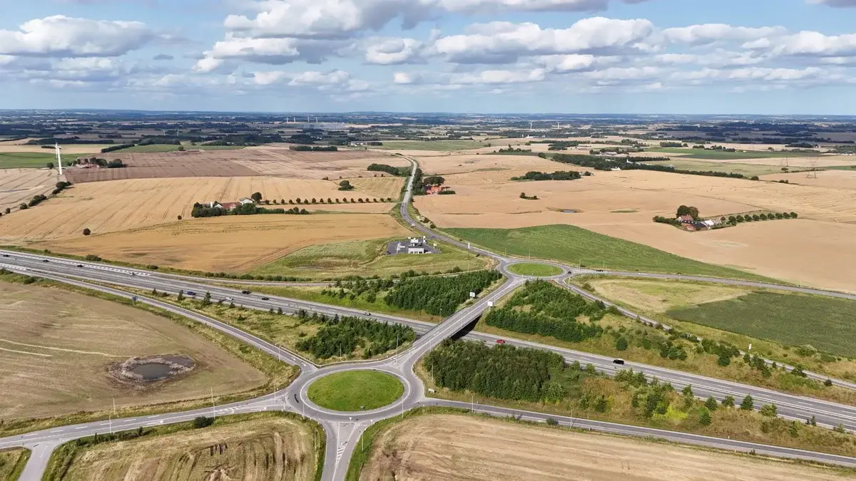 Aerial view of farmland and highways with two roundabouts in the Danish countryside.